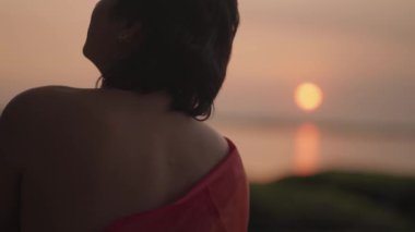 Koyu tenli Güneydoğu Asya LGBT Gay Adam Gün batımında Gökkuşağı Gurur Bayraklarıyla Sahilde Dans Ediyor