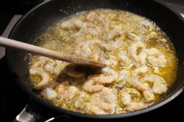 Tavada baharatlı kızarmış karides pişirmek.