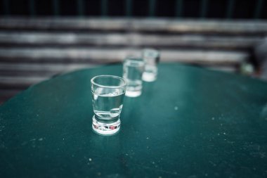 Arka planı bulanık olan votka bardaklarının görüntüsünü kapat