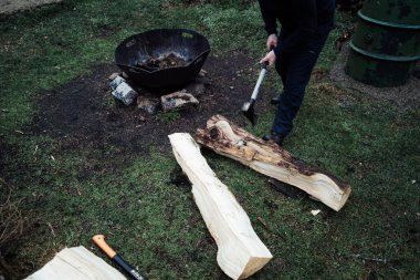 Izgara için odun kesen bir adam. Barbeküde yemek yapmak.