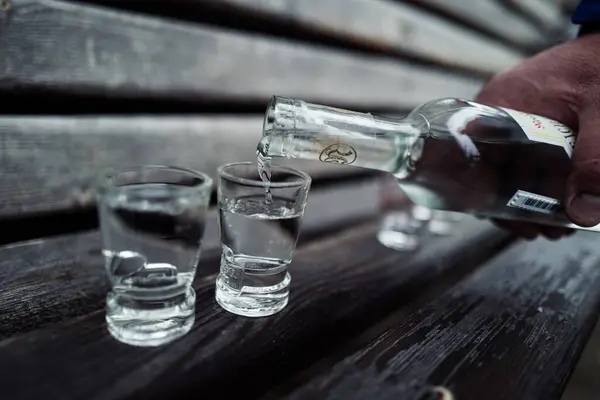 Derramando Vodka Copo Banco Madeira — Fotografia de Stock