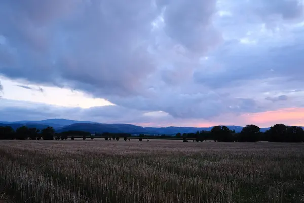 stock image beautiful cloudy sky over field in countryside during sunset