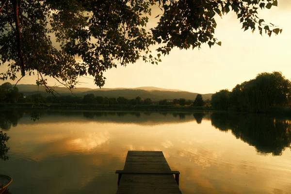 美しい日没の間に湖の木製の桟橋 — ストック写真