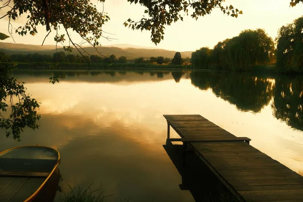Красивый Снимок Лодки Пришвартованной Возле Деревянного Пирса Озере Закате — стоковое фото