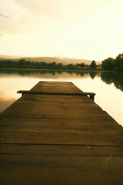 美しい日没の間に湖の木製の桟橋 — ストック写真