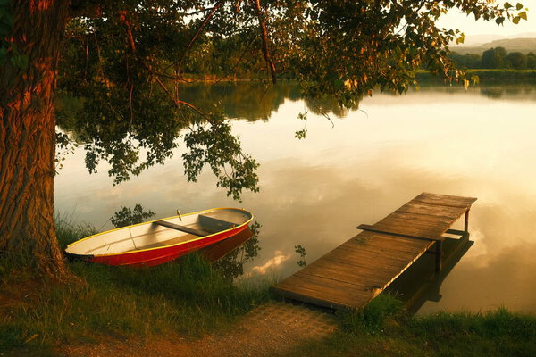 a beautiful shot of a boat on lake at sunset