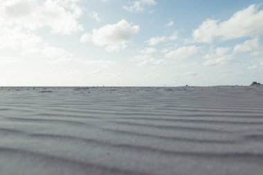 Arka planda bulutlu gökyüzü olan güzel kumullar.