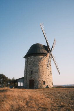 Mavi gökyüzü ve günbatımı olan eski yel değirmeni