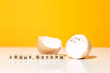 Kırık yumurta ve ahşap bloklar Mutlu Paskalya metinleri