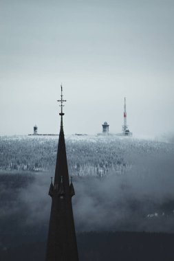 Kilise, karlı ormanın arka planına sahip.