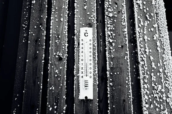 寒冷冬季木制栅栏上的温度计 — 图库照片