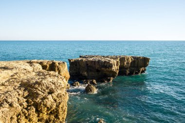Güneşli bir günde dalgalı deniz kıyısında