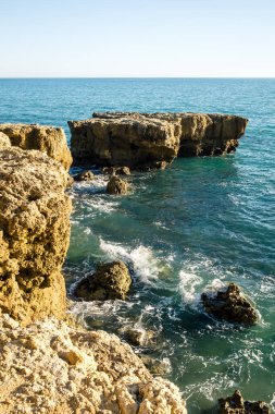 Güneşli bir günde dalgalı deniz kıyısında