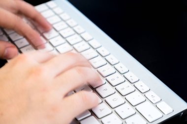 female hands typing on keyboard, close up 