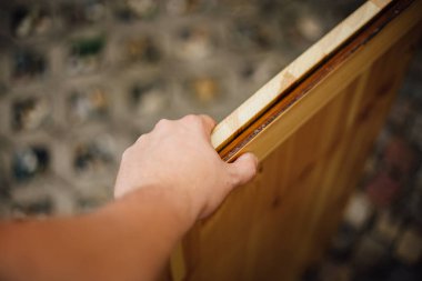 Bir adam ahşap bir kapı kuruyor.