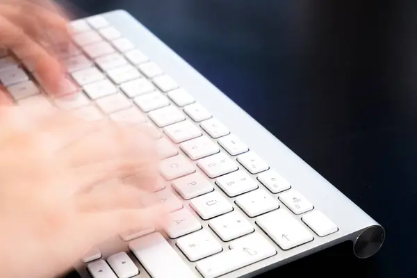 female hands typing on keyboard, close up 