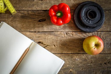 defter, biber, elma, ahşap masada mezura. Fitness konsepti. sağlıklı yaşam tarzı.