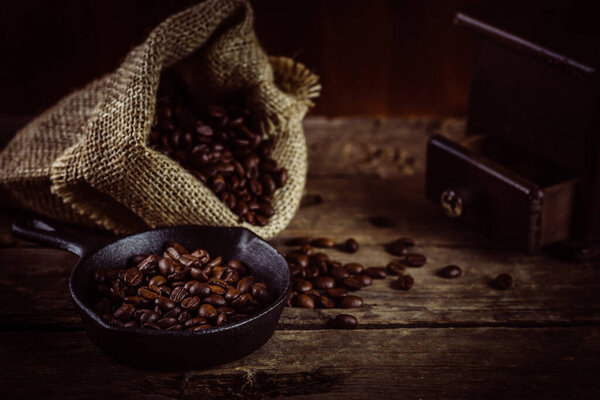 coffee grinder and coffee beans on wooden background 