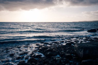 Gün batımında kayalık bir plajın güzel bir görüntüsü.