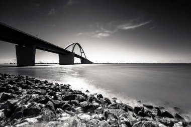 Sabahları denizin üzerinde siyah beyaz bir köprü. 