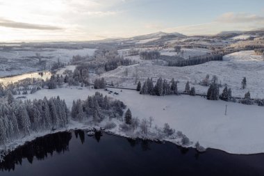 Güzel karla kaplı ormanı olan sakin nehrin havadan görünüşü     