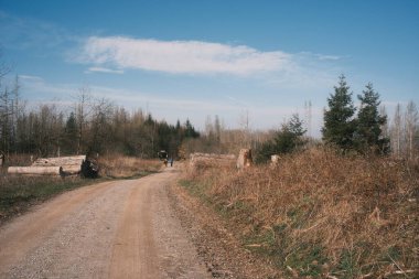 Ormandaki toprak yolda sırt çantalı bir grup insanın arka planı.             