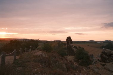 Tepedeki kaya oluşumlarıyla ve manzaralı günbatımıyla güzel bir manzara. 