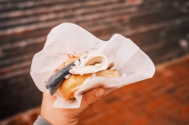 Ringa balıklı erkek el ele sandviç. 