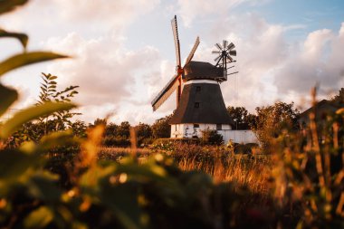 Günbatımında gökyüzü olan eski yel değirmeni manzarası