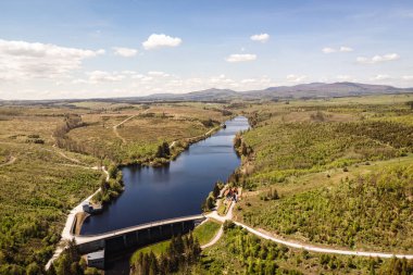 Güneşli bir günde güzel bir nehir manzarası ve yeşil arazi.