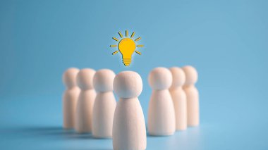 Yaratıcı fikir ve yenilik kavramı ve ampul ikonu, insan ahşap liderlik.