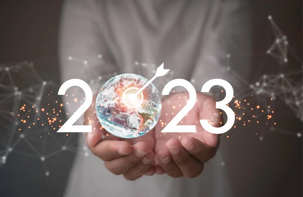 2023 globe with dartboard icon in hand businessman. Goal, Target, Resolution, strategy, plan, Action, mission, motivation, and New Year start,Target business on 2023 year concept