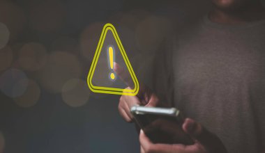 Akıllı telefon kullanan işadamı, uyarı hatası, bakım, uyarı ve güvenlik konsepti için üçgen işaretli Ünlem Uyarısı Bulunamadı