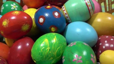 Mutlu Paskalyalar. Ev yapımı yumurta sepeti. Paskalya bayramı için renkli yumurtalarla dekoratif bir yuvanın yakınında daire şeklinde dönüyor.