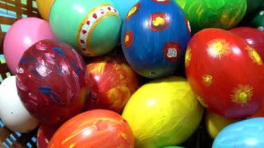 Mutlu Paskalyalar. Ev yapımı yumurta sepeti. Paskalya bayramı için renkli yumurtalarla dekoratif bir yuvanın yakınında daire şeklinde dönüyor.