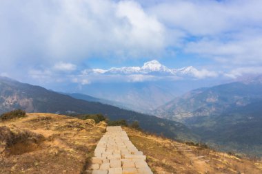 Annapurna Ana Kamp Gezisi 'nin arka planında Ghorepani köyünden Tadapani köyüne giden yol üzerinde Annapurna Sıradağları' nın bulunduğu yaya yolu ve kırsal bölge manzarası. Nepal 'deki şaşırtıcı Himalayalar