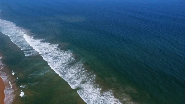 stock image Drone view of beautiful seamless  footage of Goa sea waves breaking on sandy coastline. Golden beach with deep blue ocean water and foamy waves arial shot