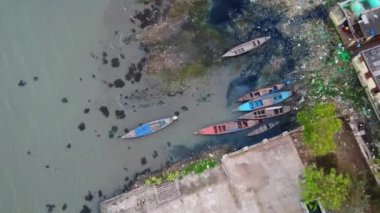Balıkçılık için denize açılmaya hazır ahşap teknelerle dolu bir limanın hava aracı görüntüleri.