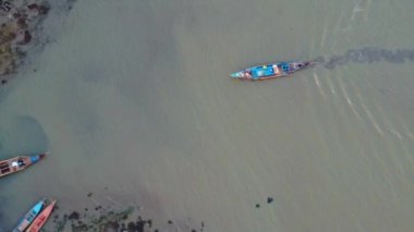 Balıkçılık için denize açılmaya hazır ahşap teknelerle dolu bir limanın hava aracı görüntüleri.