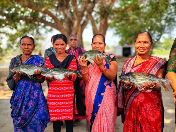 Mutlu kadın balık çiftçisi. Büyük balığı elinde tutan yardım grubu.