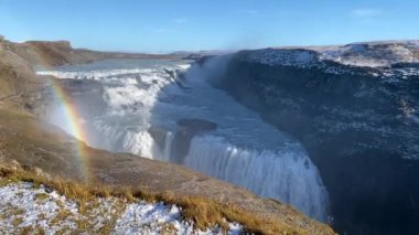 Gullfoss waterfall in Hvt river canyon in southwest Iceland. Popular falls on the Golden Circle tourism route. Rainbow in the mist from two stage cascade. 