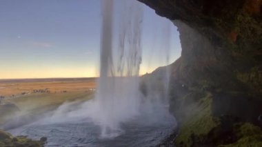 Seljalandsfoss waterfall in Iceland. Popular and beautiful waterfall along Route 1 and Ring Road. Seljalands River waters. Visitors can walk behind the falls and into cave. 