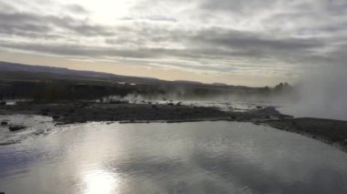 Strokkur geyser in southwestern Iceland. Erupting fountain-type geyser in Haukadalur valley on the slopes of Laugarfjall hill, which is also the home to Geysir geyser.