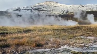 Steam rising in Haukadalur valley, Iceland. Snow on the slopes of Laugarfjall hill, which is also the home to Strokkur geyser and Geysir (The Great Geysir).