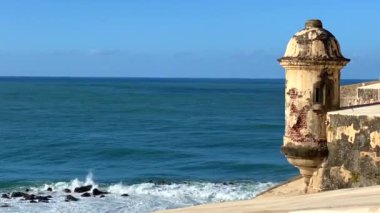 Karayip Denizi 'nin yukarısındaki Fort Wall nöbetçi kulübesi dalgaları çarpıştırıyor. Bartizan ya da Garita Castillo San Felipe del Morro, San Juan, Porto Riko 'da. Porto Riko plakası ve çeyrekliklerinde simge görünüyor. 