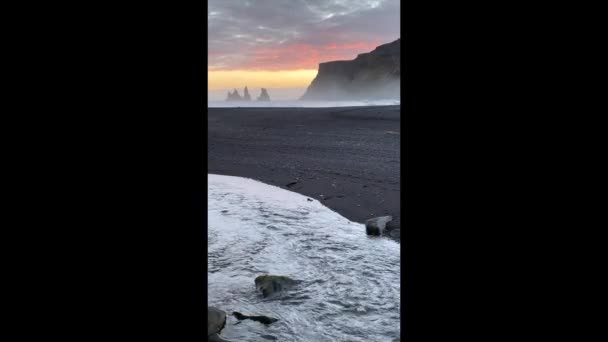 アイスランドのブラックサンドビーチビックの夕日 レイニストランガー崖や海のスタック 環状道路付近のヴィクからの崖や石積の眺め — ストック動画