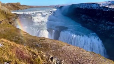 Gullfoss waterfall in Hvt river canyon in southwest Iceland. Popular falls on the Golden Circle tourism route. Rainbow in the mist from two stage cascade.