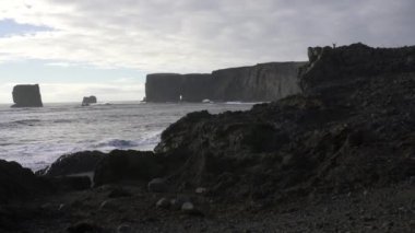 Dyrhlaey (Dyrholaey, Door Hill Adası, Cape Portland), İzlanda 'nın güney kıyısında, Vik yakınlarında yer alan küçük bir yerleşim yeri. Kirkjufjara Sahili deniz yığınları, kemer ve siyah kumsal manzarası. 