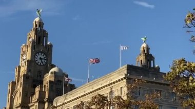 Liverpool, İngiltere: Royal Liver Binası. Kenti ve denizi koruyan karaciğer kuşları ve saatli ünlü iskele başı binası. Cunard Binası, üç incelikten ikisi. St George Cross ve Union Jack