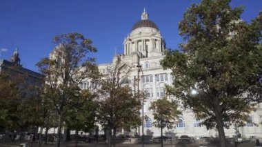 Liverpool, İngiltere - 2023: Merseyside rıhtım ve şehir silueti. Üç zarafet, Royal Liver Binası ve Liverpool Müzesi. Turistler rıhtımda yürüyor.. 